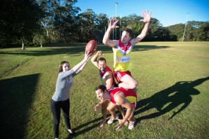 The Cancer Council's Lauren Dale hams it up with Coffs Swans players Mark Wilcox, Nic Von Schill, Pat Curtain in their special guernseys to commemorate this weekend's Cancer Awareness round. Photo: Trevor Veale / Coffs Coast Advocate
