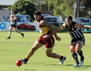 Mount Compass forward Jo Parsons tracks the ball while Goolwa defender Trent Kelly tries to hold him back